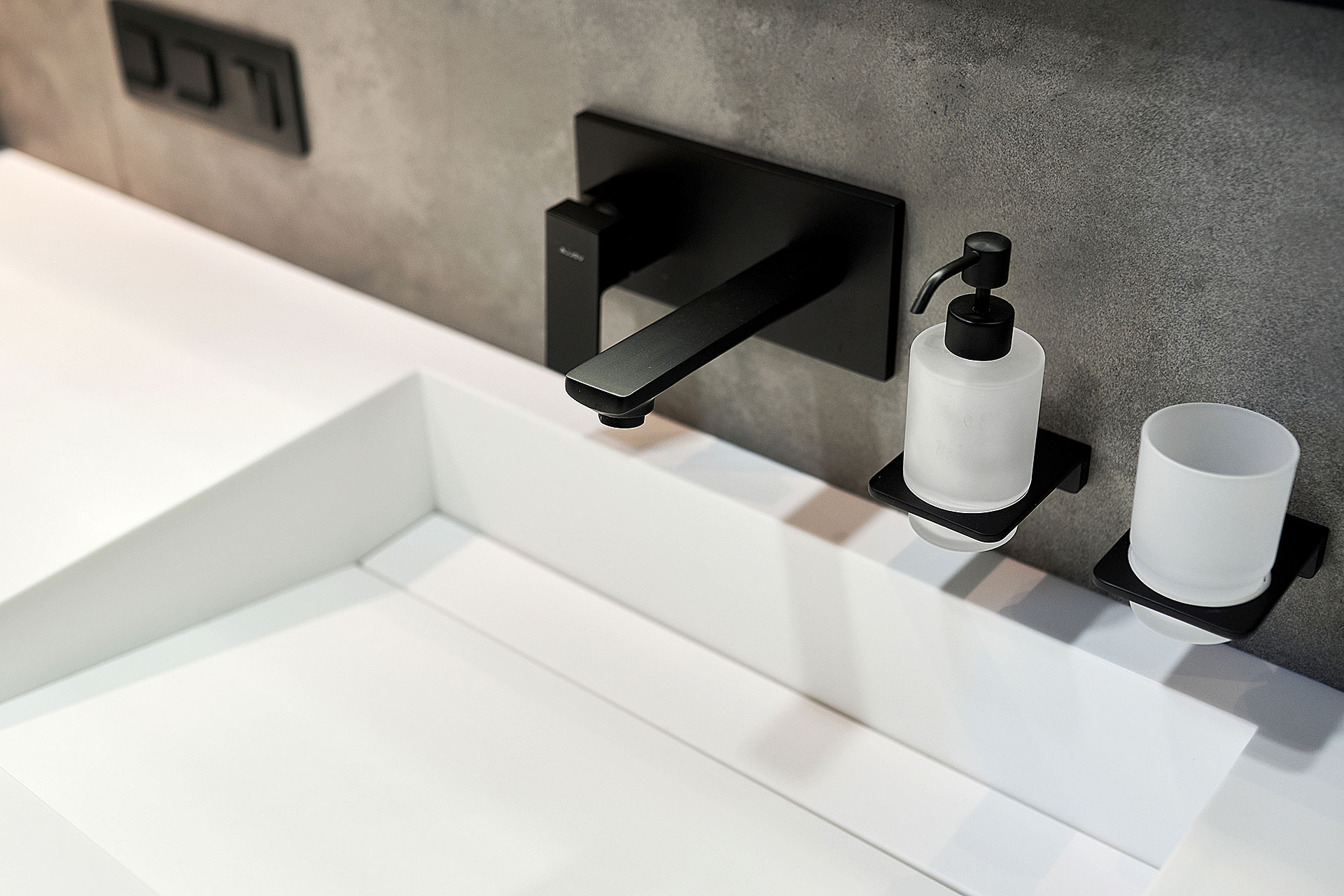 Grifería de baño en negro mate sobre lavabo, exposición de JOMASA, Gijón